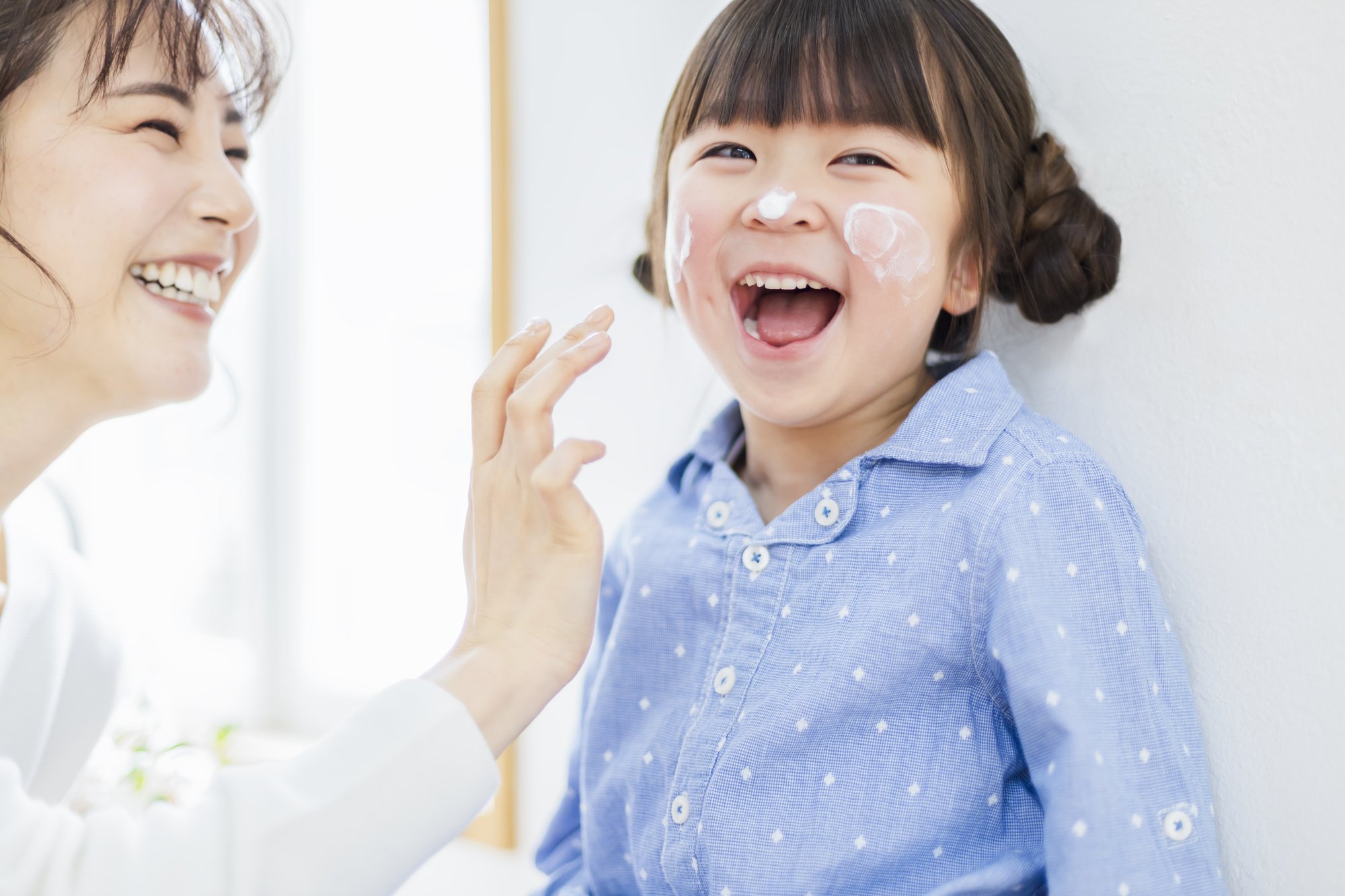 日焼け止めを塗る親子